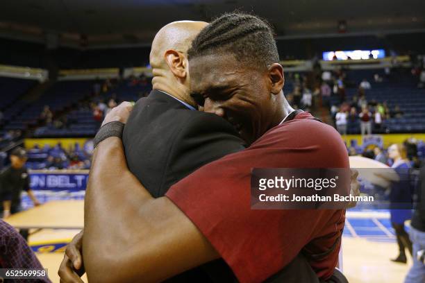 DeVon Walker of the Troy Trojans hugs a coach after the championship game of the Sun Belt Basketball Tournament against the Texas State Bobcats at...