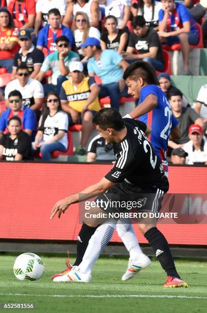 Olimpia's footballer Julian Benitez vies for the ball with Raul Caceres of Cerro Porteno during their Paraguayan Apertura 2017 football match at...