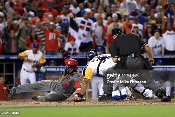 Carlos Santana of the Dominican Republic slides past the tag of Jorge Alfaro of Colombia in the 11th inning during a Pool C game of the 2017 World...