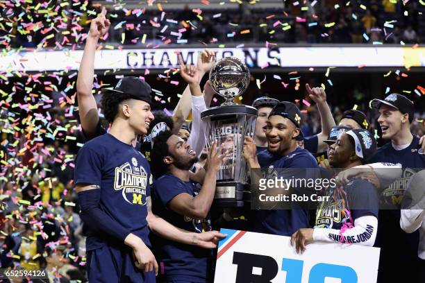 The Michigan Wolverines celebrate with the trophy after the Wolverines defeated the Wisconsin Badgers to win the Big Ten Basketball Tournament...