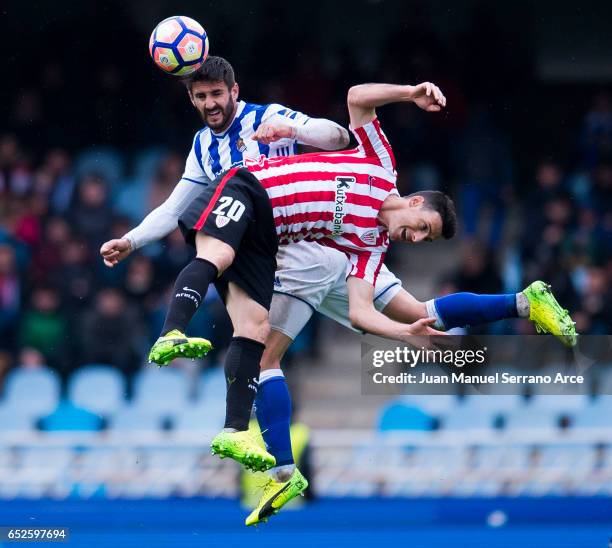 Aritz Aduriz of Athletic Club Bilbao duels for the ball with Raul Rodriguez Navas of Real Sociedad during the La Liga match between Real Sociedad de...