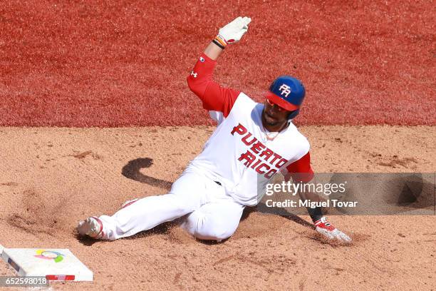 Mike Aviles of Puerto Rico slides into third base in the bottom of the fifth inning during the World Baseball Classic Pool D Game 5 between Italy and...