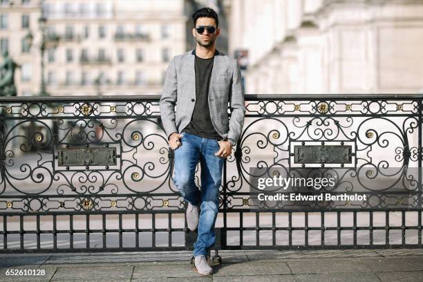 Anil Brancaleoni, Youtube influencer Wartek and blogger, wears Bobbies gray suede shoes, Replay blue denim jeans pants, a Replay t-shirt, sunglasses,...