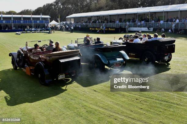Attendees drive three Rolls-Royce Silver Ghost convertible luxury vehicles during the 2017 Amelia Island Concours d'Elegance in Amelia Island,...