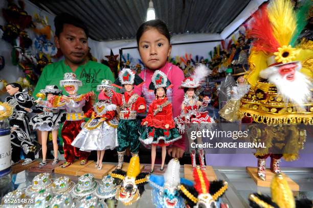 Hugo Ramos Condori creator of the Andin Barbie offers cloth and folkloric dance suits for Barbie Dolls during the Alasitas --"buy from me" in native...