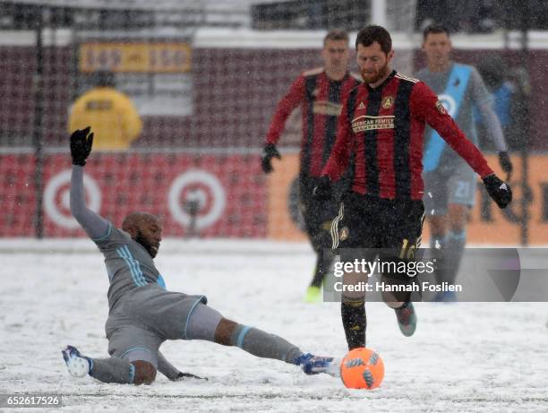 Collen Warner of Minnesota United FC slides to get the ball away from Chris McCann of Atlanta United FC during the second half of the match on March...