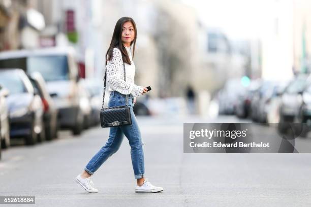 May Berthelot, Head of Legal at Videdressing.com and fashion blogger, wears a Lovie & Co white lace top, The Kooples blue denim jeans pants, Converse...