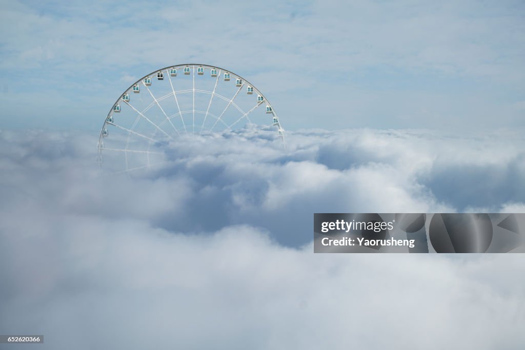 Bird view of Ferris wheel in cloud sea