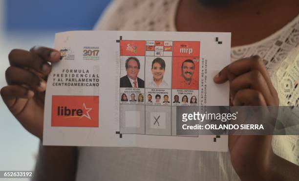 An Electoral Supreme Court staffer shows a ballot marked with a vote for Xiomara Castro candidate for Libertad y Refundacion party in Tegucigalpa, on...