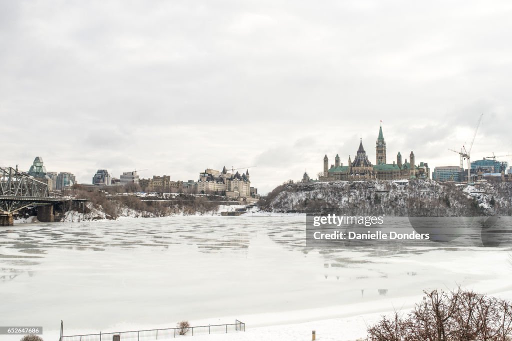 Wide angle view of frozen Parliament Buildings and downtown Ottawa in winter