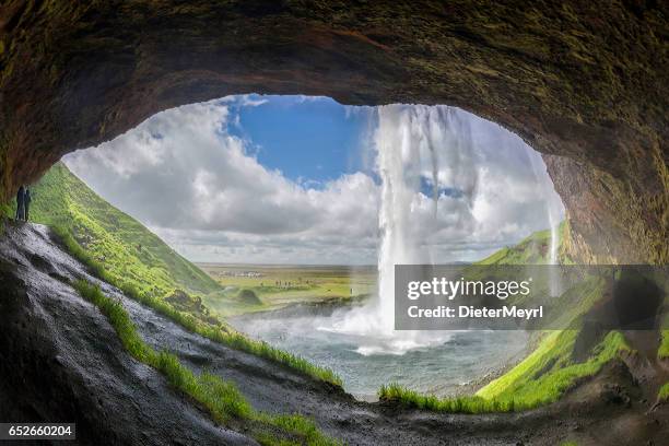 tourists discover the seljalandsfoss waterfall - seljalandsfoss waterfall stock pictures, royalty-free photos & images