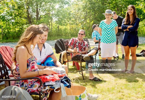 pregnant young couple opening gifts at baby shower outdoors. - outdoor baby shower stock pictures, royalty-free photos & images