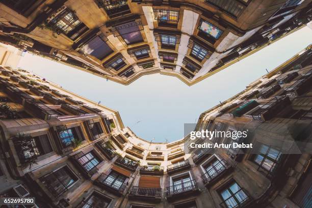 beautiful below view with wide angle lens taken from the ground and looking up of the beautiful streets of gothic quarter in barcelona city with narrow street and nice round square. - fish eye lens stockfoto's en -beelden