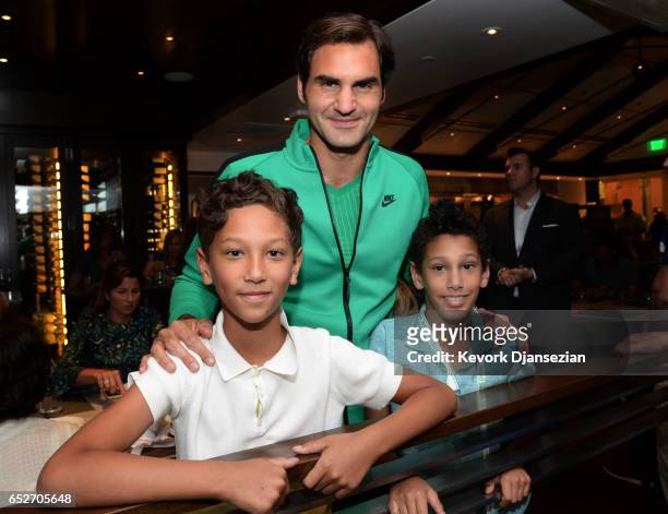 Roger Federer, poses with the children of celebrity chef Wolfgang Puck Oliver Puck and Alexander Puck inside Spago at Desert Champions overlooking...