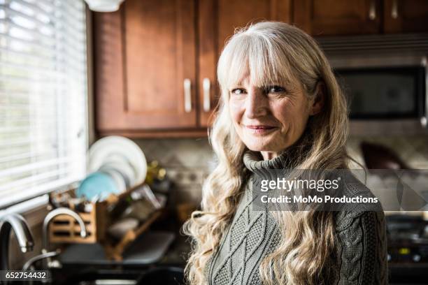portrait of woman (60yrs) in kitchen - 60 64 ans photos et images de collection