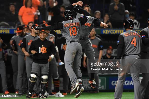 Desingated hitter Didi Gregorius of the Netherlands celebrates with Infielder Xander Bogaerts after hitting a three run homer to make it 10-0 in the...