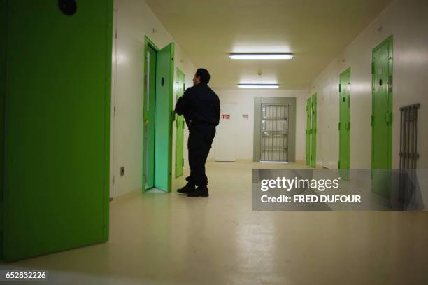 Cette photo, prise le 02 avril 2009 au nouveau centre pénitencier de Lyon-Corbas dans la banlieue de Lyon, montre un surveillant ouvrant une cellule....