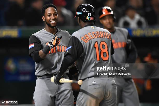 Outfielder Jurickson Profar of the Netherlands congratulates after scoring a run by a sacrifice fly of Desingated hitter Didi Gregorius to make it...