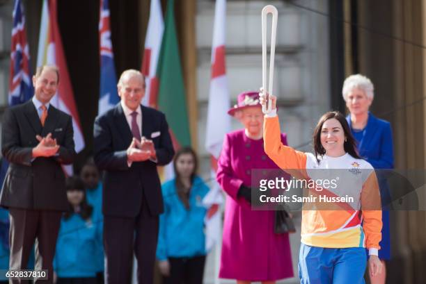 Anna Meares carries the Commonwealth baton as Queen Elizabeth II, Prince Philip, Duke of Edinburgh and Prince Edward, Earl of Wessex look on during...