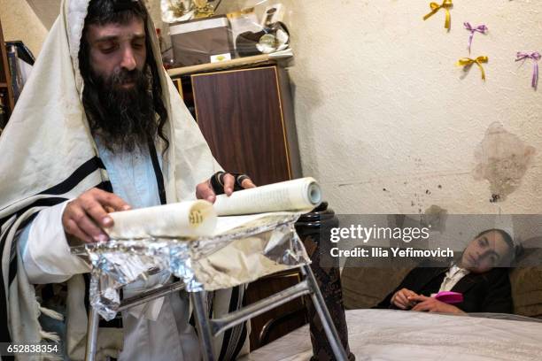 Ultra Orthodox family seen reading the book of Esther on March 13, 2017 in Jerusalem, Israel. The carnival-like Purim holiday is celebrated with...