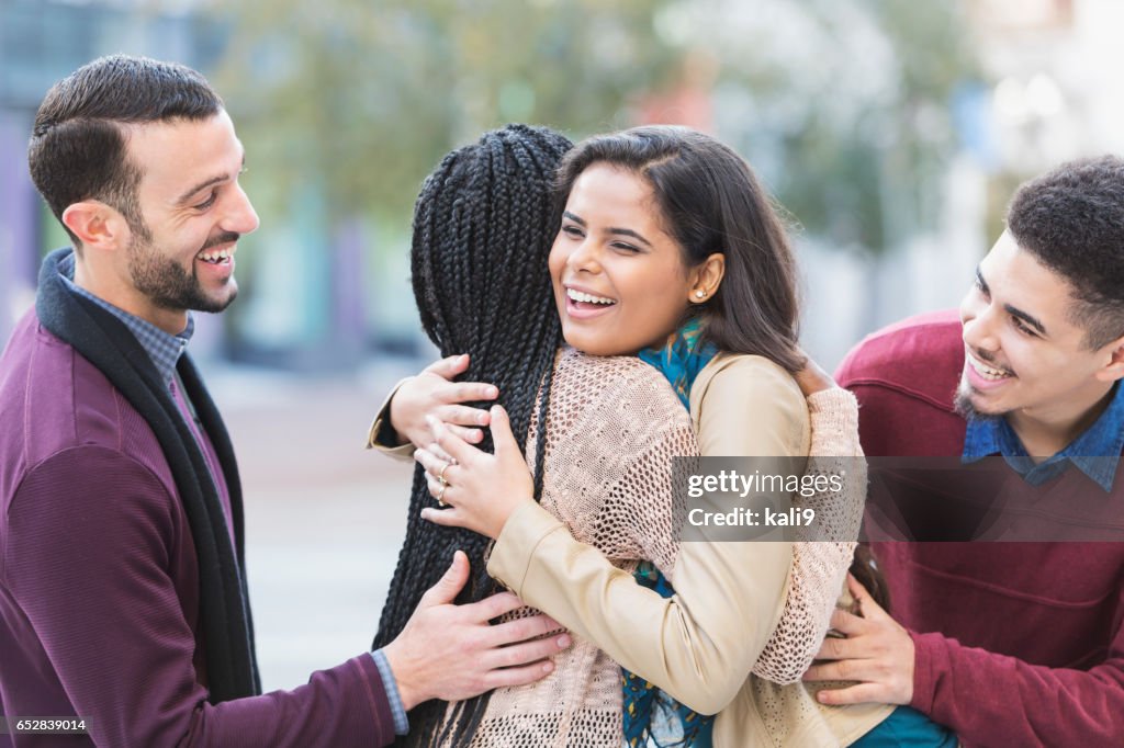 Deux jeunes couples réunis, salutation sur rue de la ville