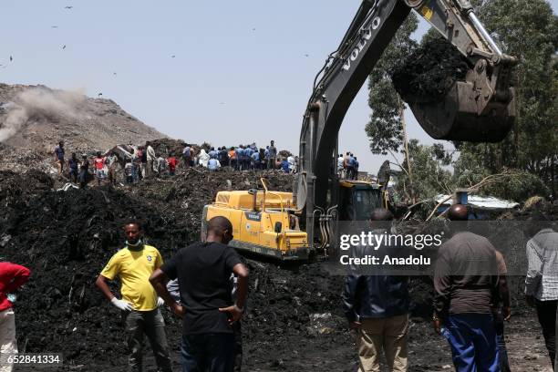 Rescue workers search for those buried by a landslide that swept through a massive garbage dump, killing at least 46 people and leaving several...