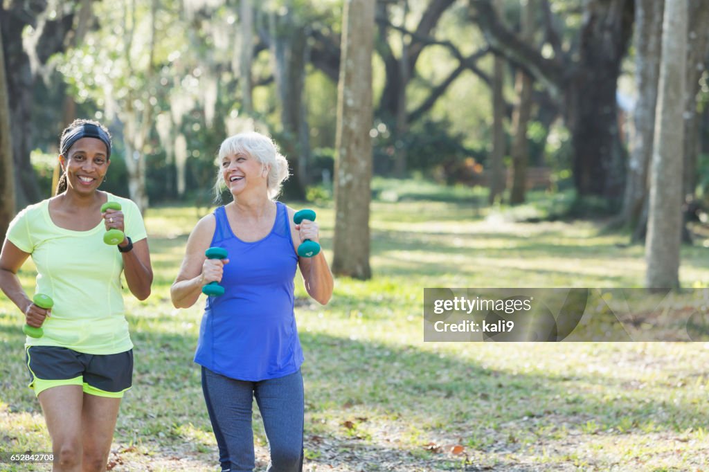 手の重みで年配の女性が公園で運動を実行します。