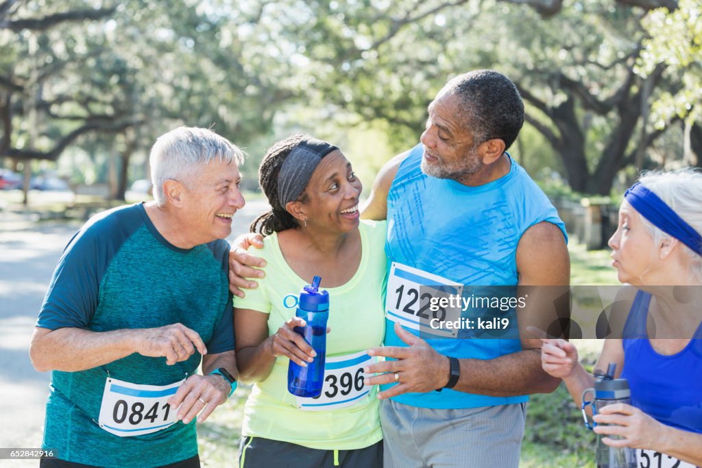 Twee multi-etnische senior paren aan einde van race