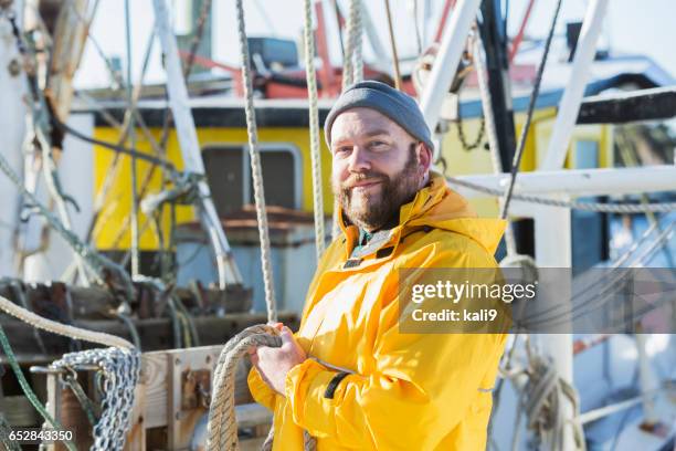 homme d’âge mûr travailler sur bateau de pêche commerciale - chalutier photos et images de collection