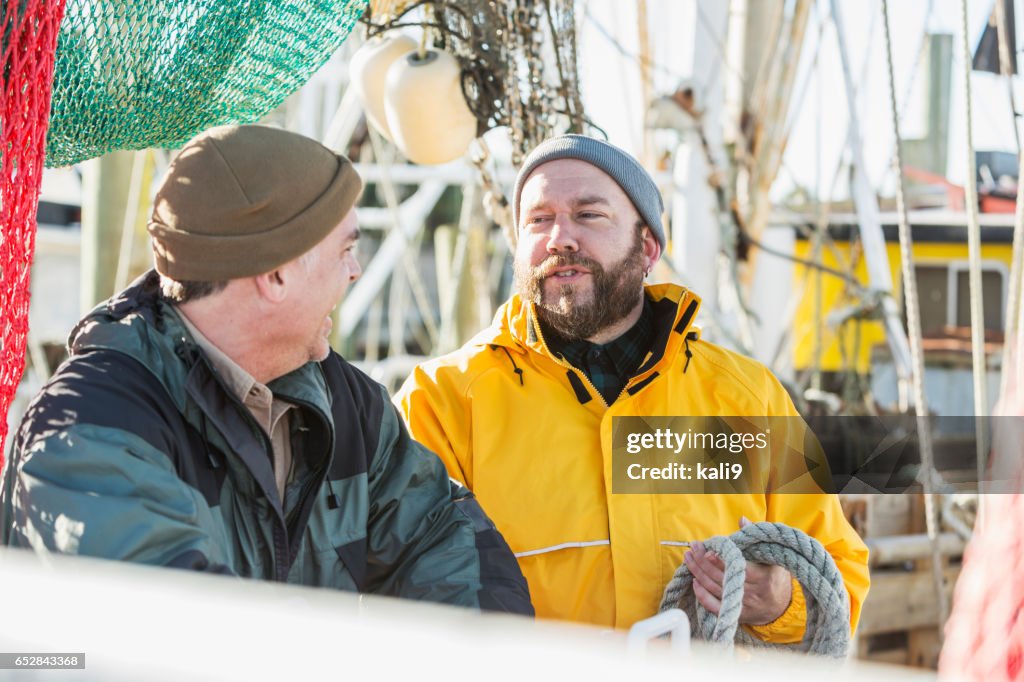 Two mature men working on commercial fishing boat