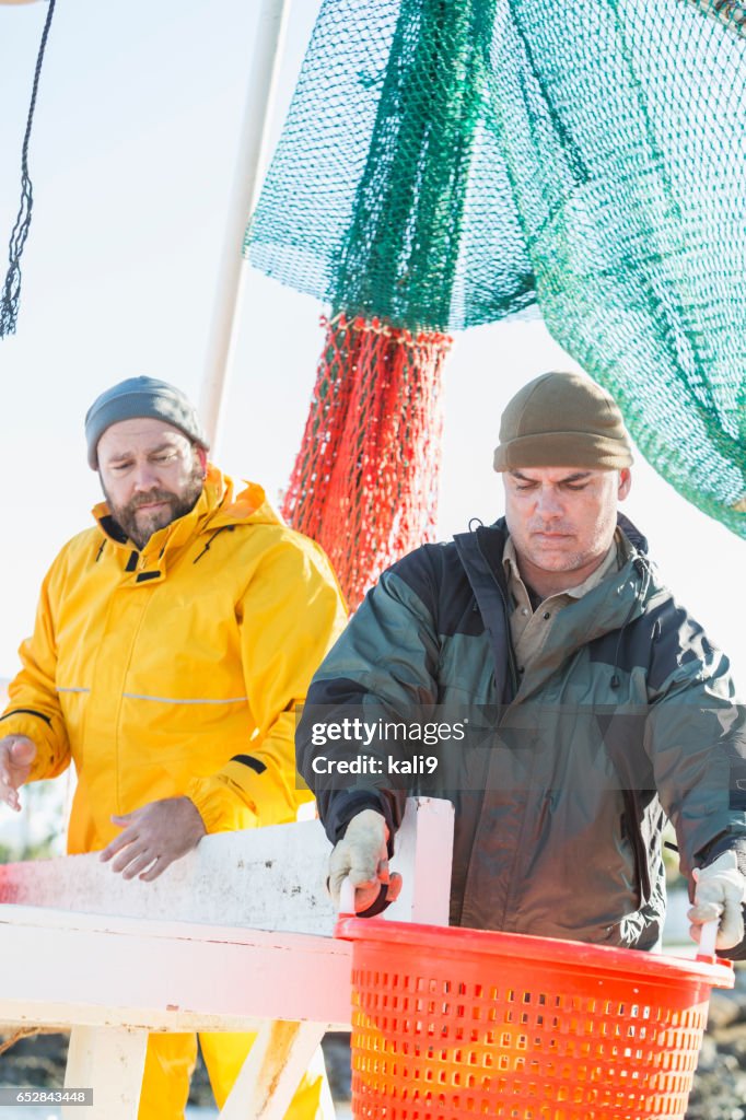 Men working on commercial shrimp boat unloading basket