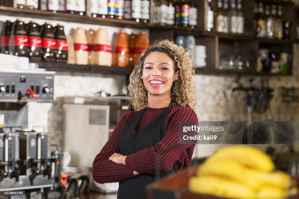 Jonge vrouw achter balie werken bij koffiehuis