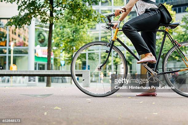 legs of a young businesswoman on a bicycle - radfahren stock-fotos und bilder