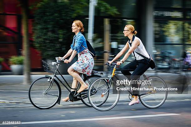two women cycling in the city - radfahren stock-fotos und bilder
