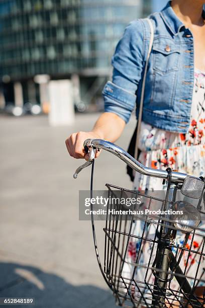 woman's hand holding bicycle handle bar - denim jacket close up stock pictures, royalty-free photos & images