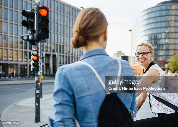 two women on bicycle waiting on traffic light - stoplight photos et images de collection