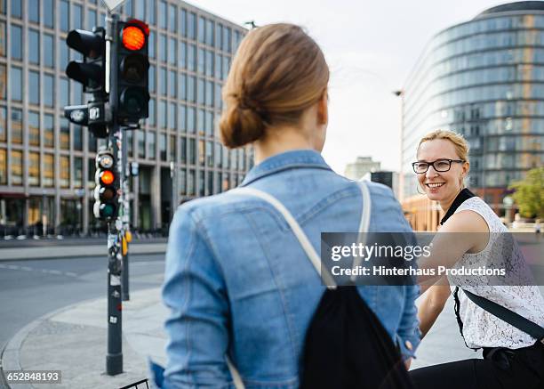 two women on bicycle waiting on traffic light - 赤信号地区 ストックフォトと画像