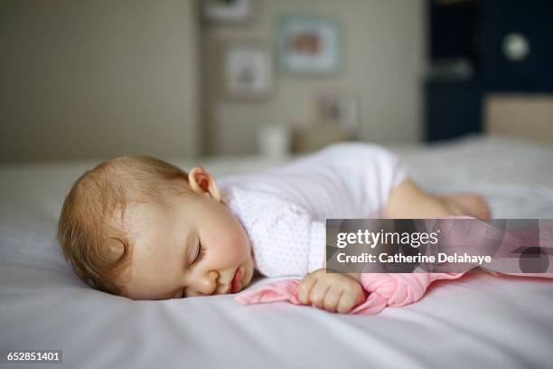 a 7 months old baby sleeping on a bed - soltanto un neonato maschio foto e immagini stock