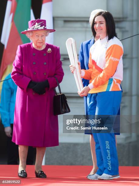 Anna Meares receives the Commonwealth baton from Queen Elizabeth II during the launch of The Queen's Baton Relay for the XXI Commonwealth Games being...