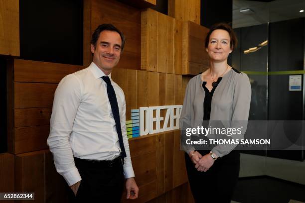 French Alexis de Gemini, CEO of Deezer France, and French Coralie Piton, Fnac-Darty strategy director, pose in Paris, on March 13, 2017. - Fnac and...