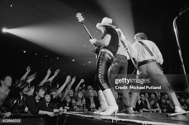 Dave Hill performing with Noddy Holder and Jim Lea of British rock group Slade, 1981.