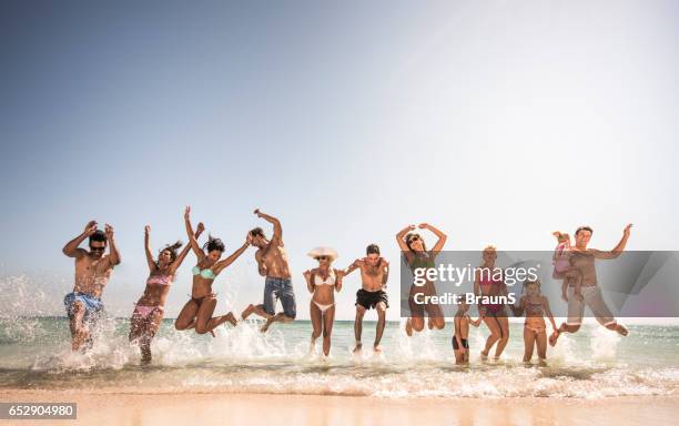 large group of playful people jumping on the beach. - egyptian family stock pictures, royalty-free photos & images