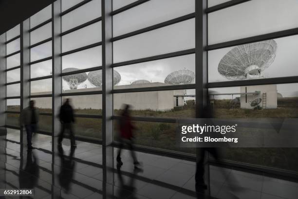 Employees walk past satellite antennas at the Bolivian Space Agency Amachuma Ground Station stands in Achocalla, La Paz Department, Bolivia, on...