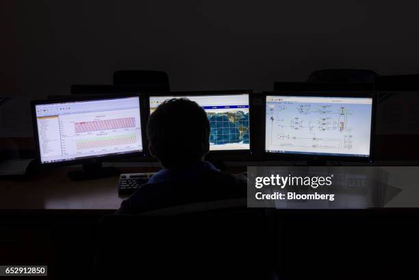 An engineer views monitors displaying telemetry data from a satellite inside the Communication Operation Control Center at the Bolivian Space Agency...