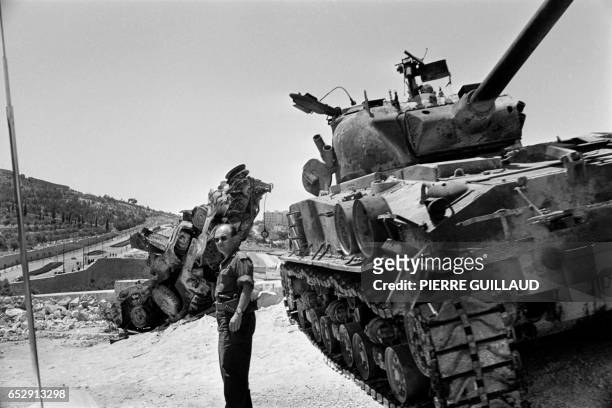 An Israeli soldier checks a destroyed tank on the road between Bethleem and Jerusalem in June 1967 during the 1967 Arab-Israeli war. On 05 June 1967,...