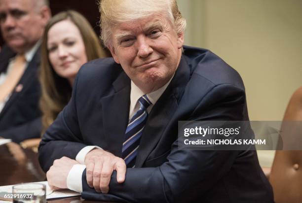 President Donald Trump attends a meeting about healthcare in the Roosevelt Room at the White House in Washington, DC, on March 13, 2017. / AFP PHOTO...