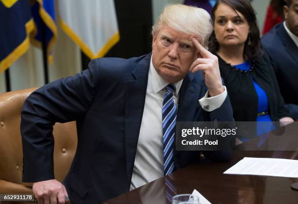 President Donald Trump attends a meeting on healthcare with Carrie Couey of Colorado in the Roosevelt Room of the White House on March 13, 2017 in...