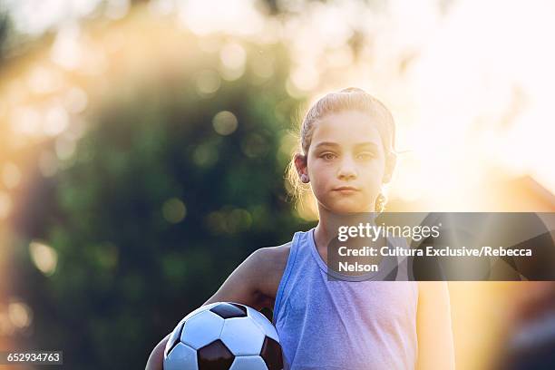 portrait of girl holding football looking at camera - young girl soccer stock pictures, royalty-free photos & images