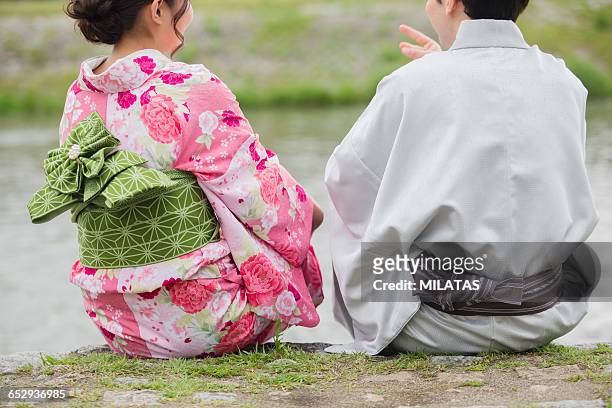 japanese couples sit in river beach - yukata stock-fotos und bilder