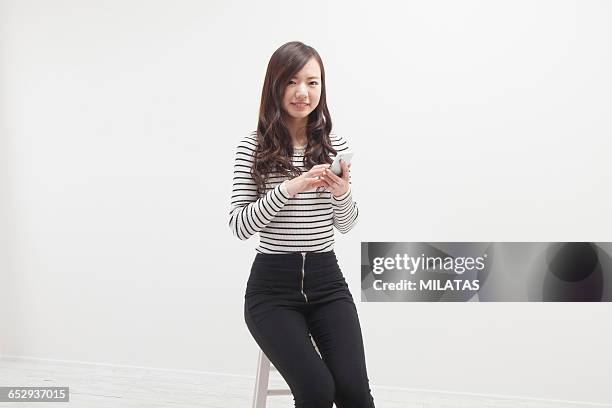 young japanese woman portrait - sitting and using smartphone studio stock pictures, royalty-free photos & images